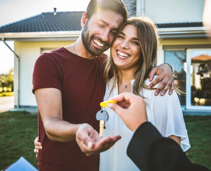 un couple achetant une maison reçoit avec bonheur les clefs du bien